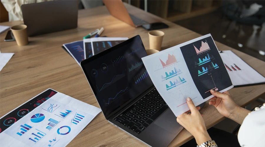 Laptop ekranında ve kağıtlarda veri görselleştirmeleri